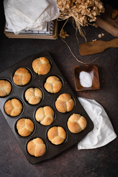 istock Freshly Baked Homemade Cloverleaf Rolls in Muffin Tin: Rustic, Dark Background 1219197534