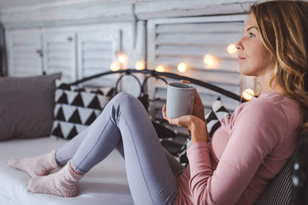 istock Beautiful young woman drinking coffee at home 1219203881