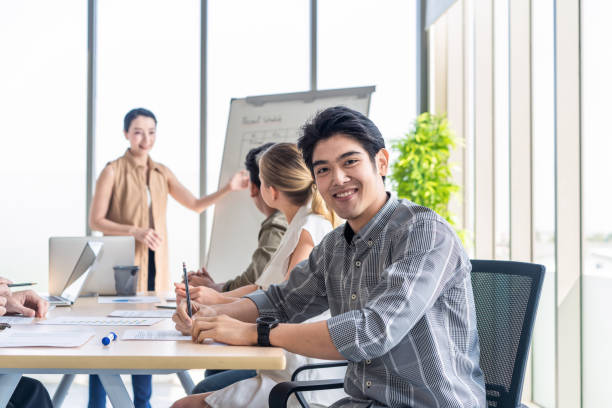 istock Asian man and team work brainstorm to solve problem and presentation new idea. People discuss and smile on new challenge topic in meeting room. Business finance and communication planning concept. 1219205523
