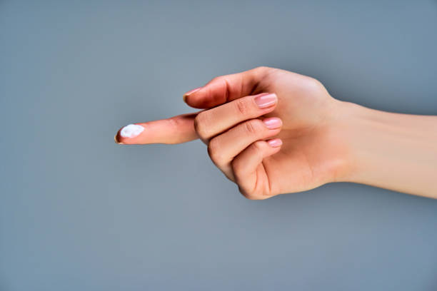istock Close-up female hand with white cream on forefinger. Cosmetics concept 1219205699