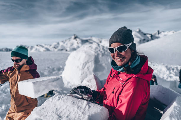 istock Friends carve snow to build igloo 1219206565
