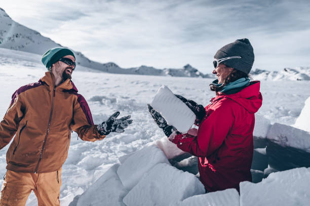 istock Friends carve snow to build igloo 1219206567