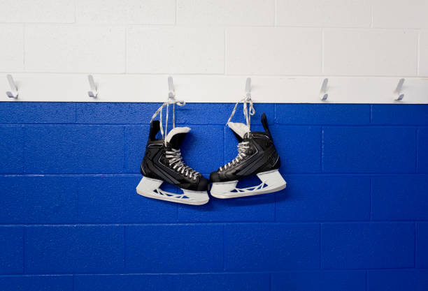istock Hockey skates hanging over blue wall with copy space 1219209668