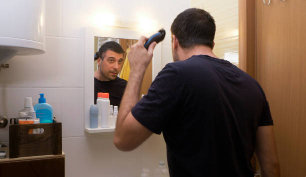 istock Man cutting his own hair with a clipper 1219210511