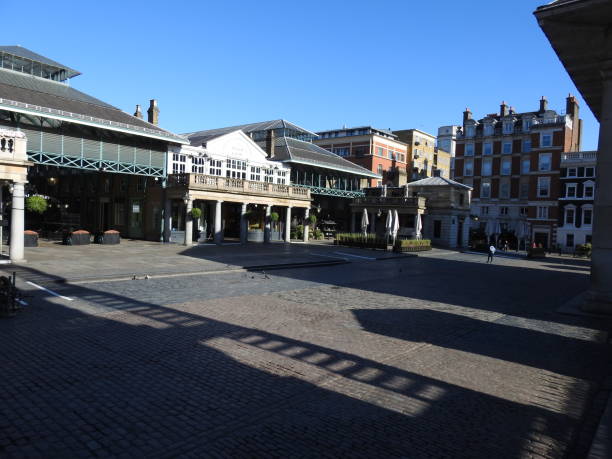 Coronavirus London Lockdown - Covent Garden market is empty during the coronavirus pandemic London / UK - March 23rd 2020: London's normally busy Covent Garden and Neal Street, popular tourist destinations are nearly empty as people are told to  self isolate during the COVID-19 coronavirus paternoster square stock pictures, royalty-free photos & images