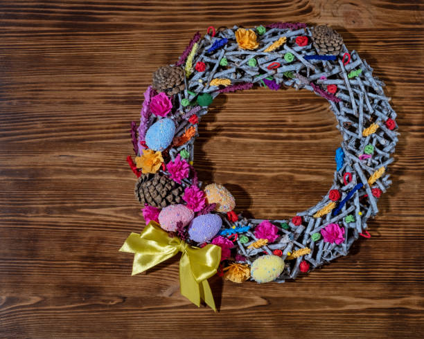 istock Easter wreath. Beautiful spring holiday wreath from branches, cones and  Easter eggs on colorful  background 1219216063