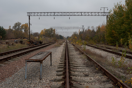 Empty abandoned train tracks leading into the distant vanishing point in Pripyat, Chernobyl Exclusion Zone