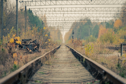 Empty abandoned train tracks leading into the distant vanishing point in Pripyat, Chernobyl Exclusion Zone