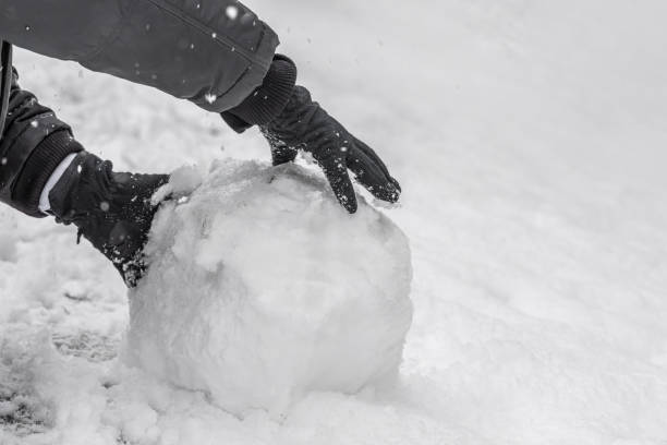 istock A man in black gloves makes a snowman in a winter day 1219217355