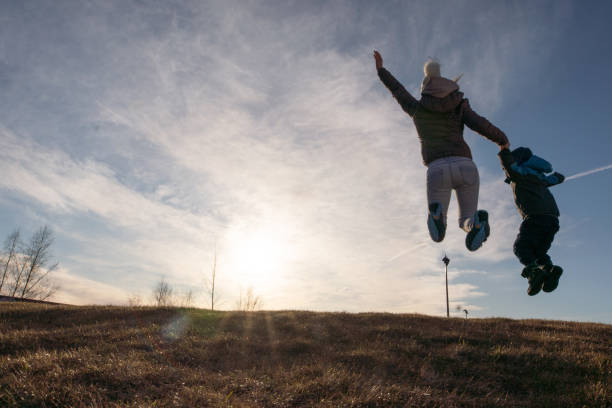 istock Little boy with mother jumping on the meadow 1219218533