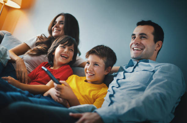 istock Young family watching tv at home. 1219218685