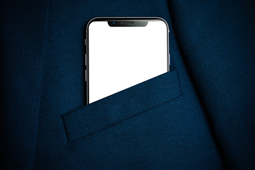 Black smartphone with white screen in men suit pocket close up. Copy space, mockup
