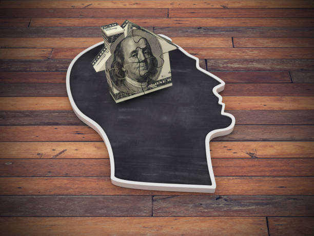 istock Human Head Shape with Dollar Puzzle House on Wood Floor - 3D Rendering 1219219560