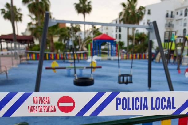 Children's playground closed by police with cordon tape Spanish police close a children's play area cordoning off the playground with police cordon tape. The playground is in town of Sabiniillas on the Costa Del Sol, Spain near the beach. Various play equipment including swings and a seesaw can be seen in the background of the image with police cordon tape being the prominent feature. childrens day photos stock pictures, royalty-free photos & images