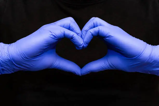 Blue latex gloves for medical protection in heart form symbol, support the doctors and nurses, Covid-19, coronavirus. red background black background