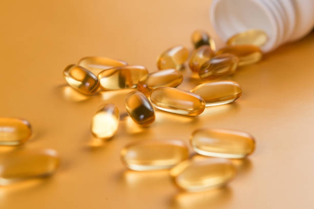 beaucoup de capsules oméga 3 sur fond jaune. fermez-vous vers le haut, produit haute résolution. concept de soins de santé. - capsule fish oil fish pill photos et images de collection