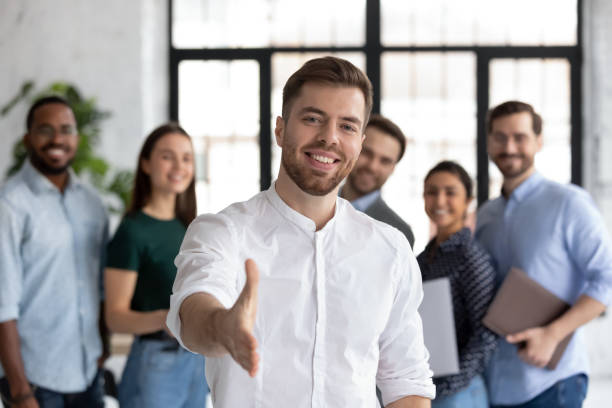 feliz hombre de negocios estirar la mano saludando recién llegado en la oficina - education business people men fotografías e imágenes de stock