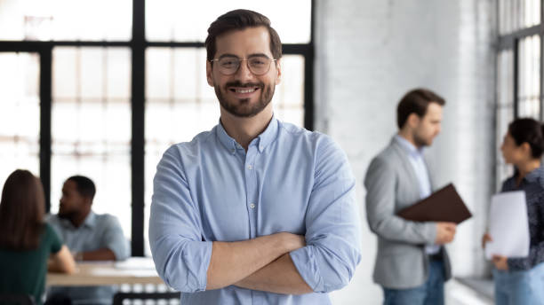Smiling male CEO posing alone in modern office Smiling young Caucasian businessman in glasses stand in modern office show confidence and motivation at work, happy millennial European male CEO posing at workplace, leadership, success concept chief leader photos stock pictures, royalty-free photos & images