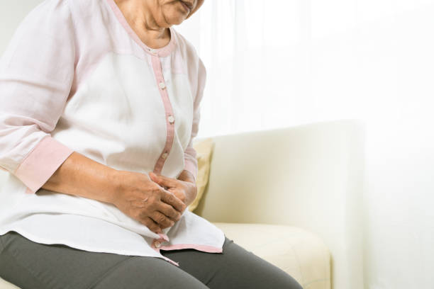 douleur d’estomac de la vieille femme à la maison, problème de soins de santé du concept aîné - human large intestine photos et images de collection