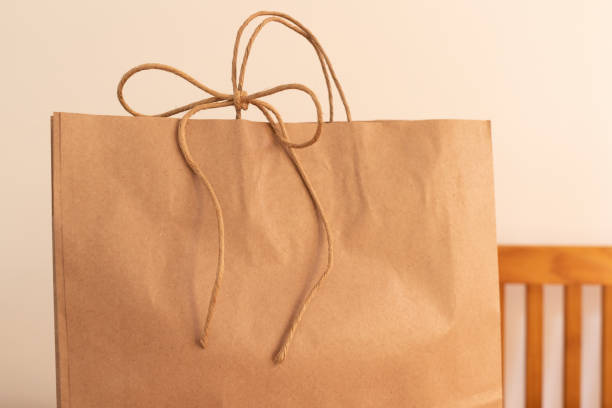 istock Delivery. Craft paper bag tied with cute rustic bow 1219226292