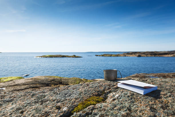 istock A mug with a book on a stone seashore. 1219226530