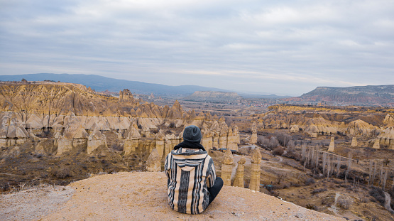 Epic valley landscape photography with a man between geologic rock formations in Cappadocia, Turkey
