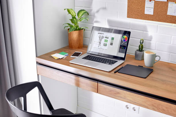 istock Modern workplace table with plants, laptop computer, graphic design tablet and smartphone 1219234152