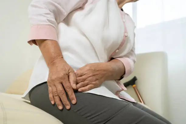 Photo of Hip pain of senior woman at home, healthcare problem of senior concept