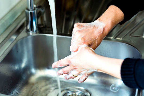istock a young caucasian woman washing her hands with soap 1219238067