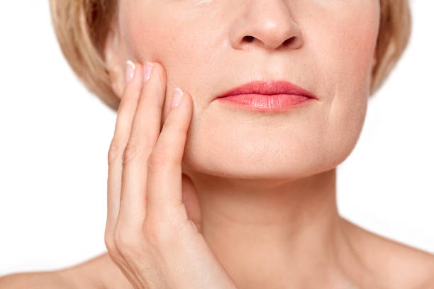 istock Middle aged female touching her cheek with hand 1219238702