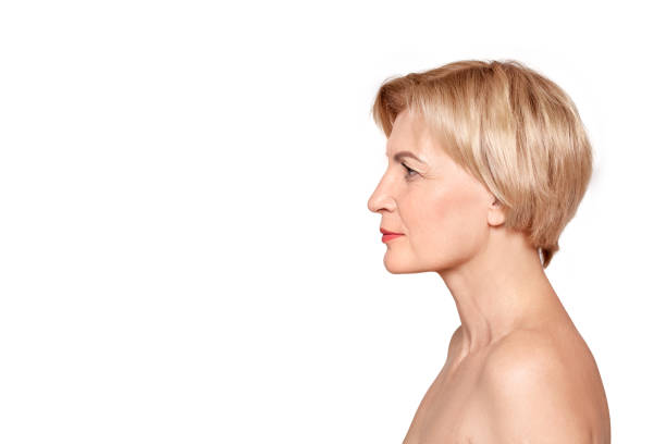 istock Mature aged female with calm face standing against light grey background 1219238703
