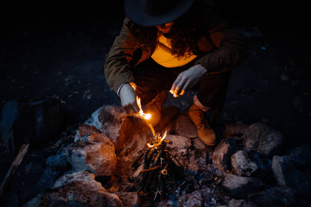 istock Man lighting a fire at dusk on a camping trip in New York 1219238758