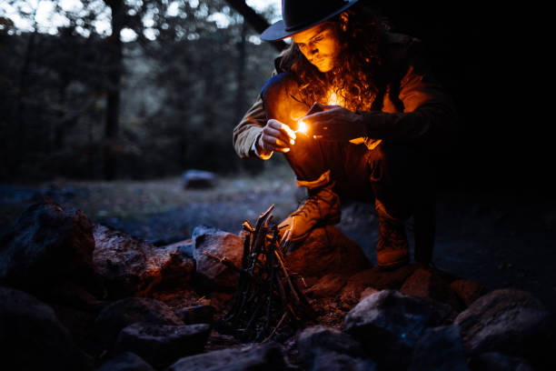 istock Man lighting a fire at dusk on a camping trip in New York 1219239325