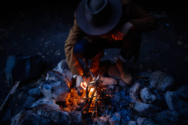 istock Man lighting a fire at dusk on a camping trip in New York 1219240266