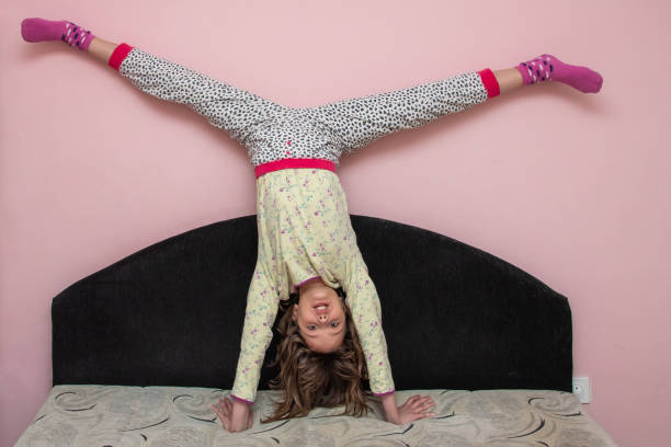 istock Cute little girl standing on the hands on a sofa 1219240472