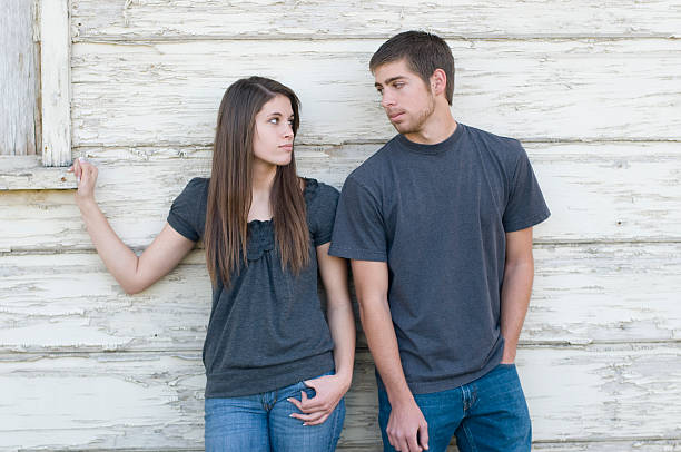 Teenage couple glaring in disagreement stock photo