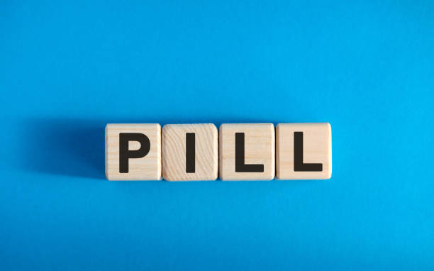 istock PILL - text on wooden blocks, medical concept, blue background 1219242083