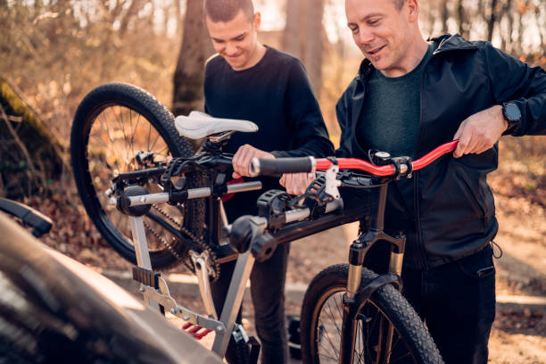 father and son take the bike down from the rack on the car father and son take the bike down from the rack on the car bicycle rack photos stock pictures, royalty-free photos & images