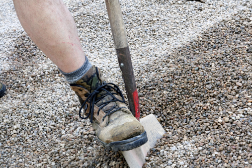 Old shovel on gravel, close-up. Shovel lies with rubble. Construction work concept