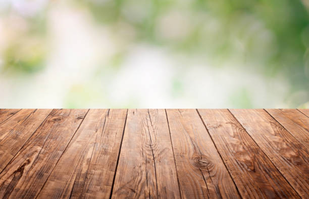 istock Empty wooden brown tabletop with a blurry, defocused garden. Summer is spring. For installation of a product display or visual design of a key, environmental product advertising template. Space 1219252756