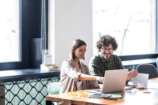 istock Casual Business: Man and Woman Sitting at the Office and Working Together on a Laptop Computer 1219254600