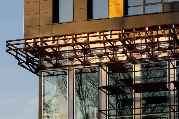 Photo of Finishing the facade of the building with a ventilated facade. A fragment of a residential building, hotel, hospital or other commercial property with glazed windows and building loess