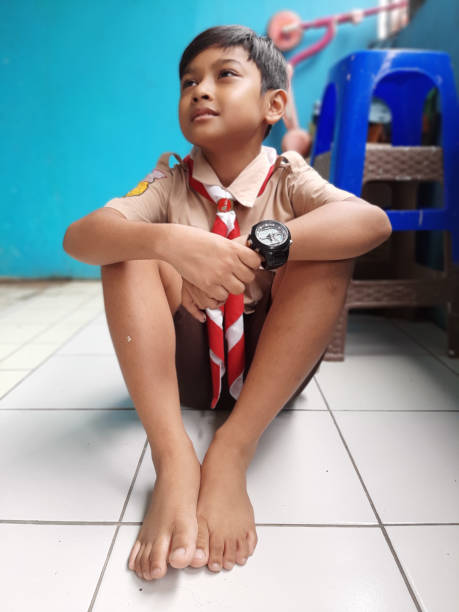 This young Asian boy is wearing his Scout Uniform as he lets us grab a few snapshots of him during recess at his school.