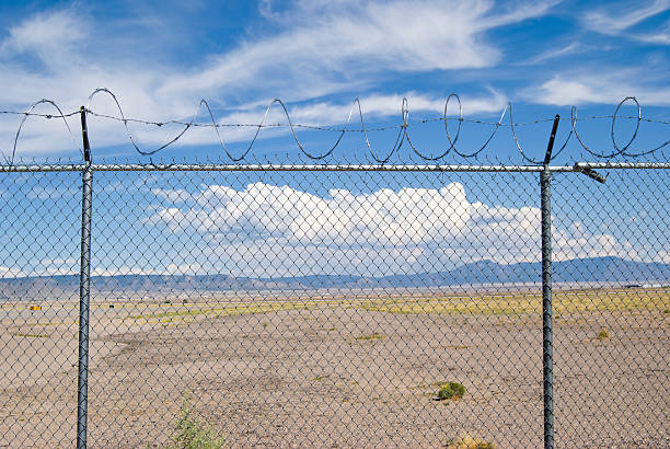 istock Blue Sky and Fluffy Clouds Behind Barb Wire Fence 121926210