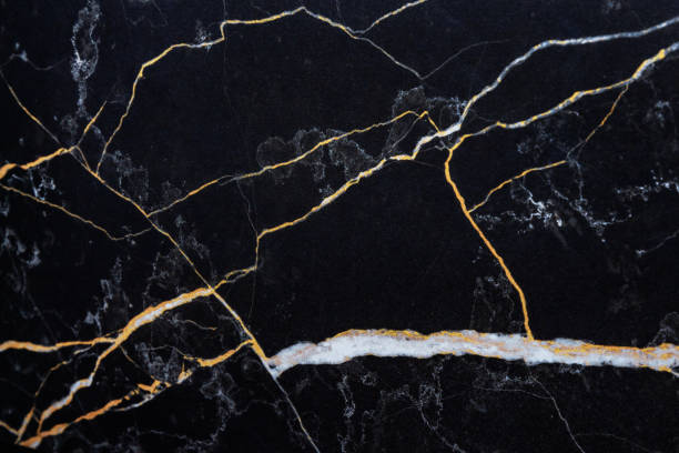 black marble with Golden lines, natural black marble texture. White and yellow patterned natural details in dark grey marble. Textured background for interior or product design