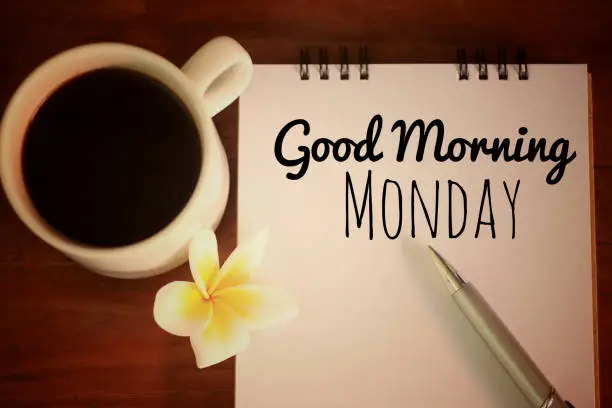 Photo of Good morning Monday. Handwriting text greeting on notebook with morning coffee.