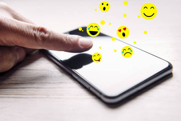 istock finger touching a phone that emojis come out of 1219263659