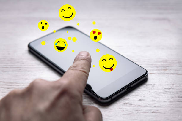 istock finger touching a phone sending emojis come out of 1219263662