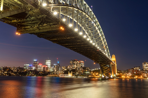 Sydney Harbour Bridge at dusk. View across Sydney Harbour to skyline of North Sydney, New South Wales, Australia.