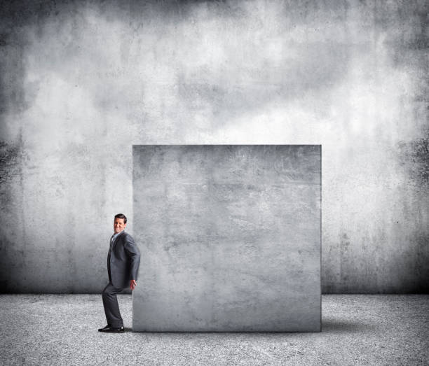 istock Businessman Attempting To Push Large Concrete Block 1219270753